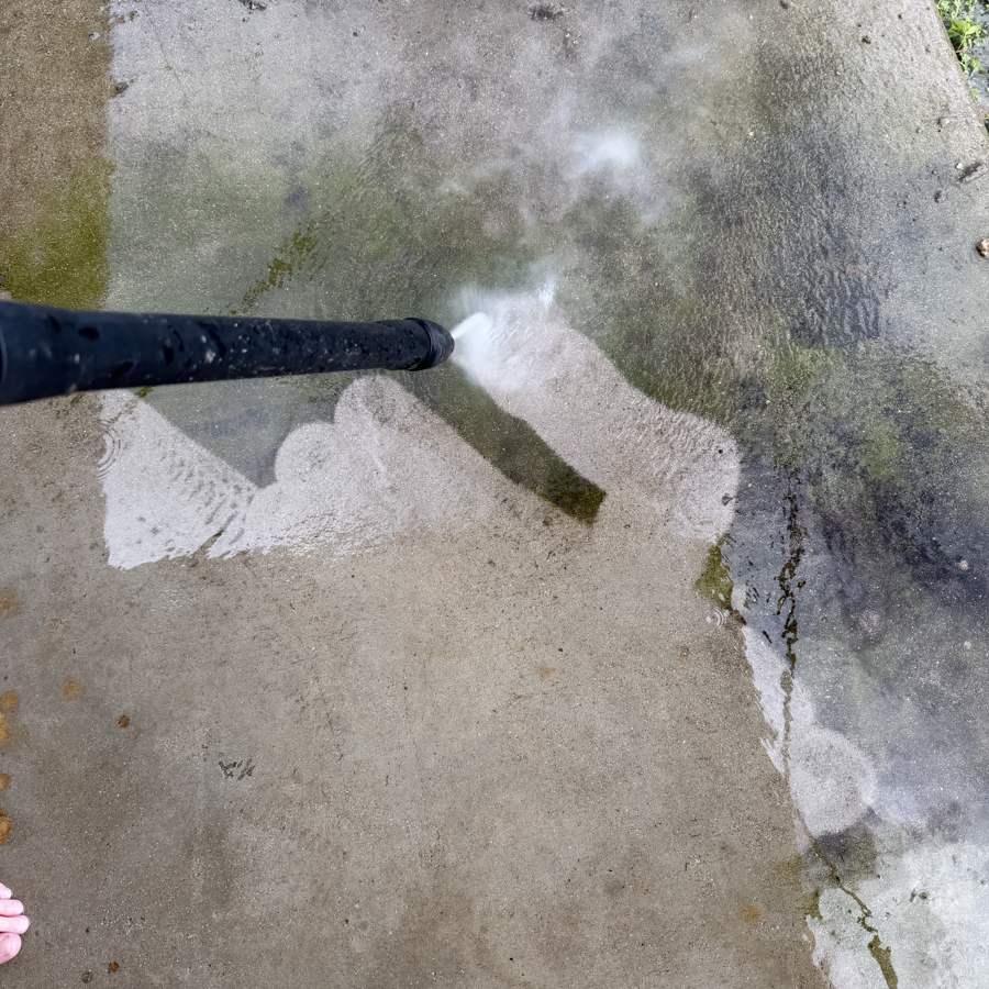 Pressure washing grime off concrete before a bond inspection in Airlie Beach